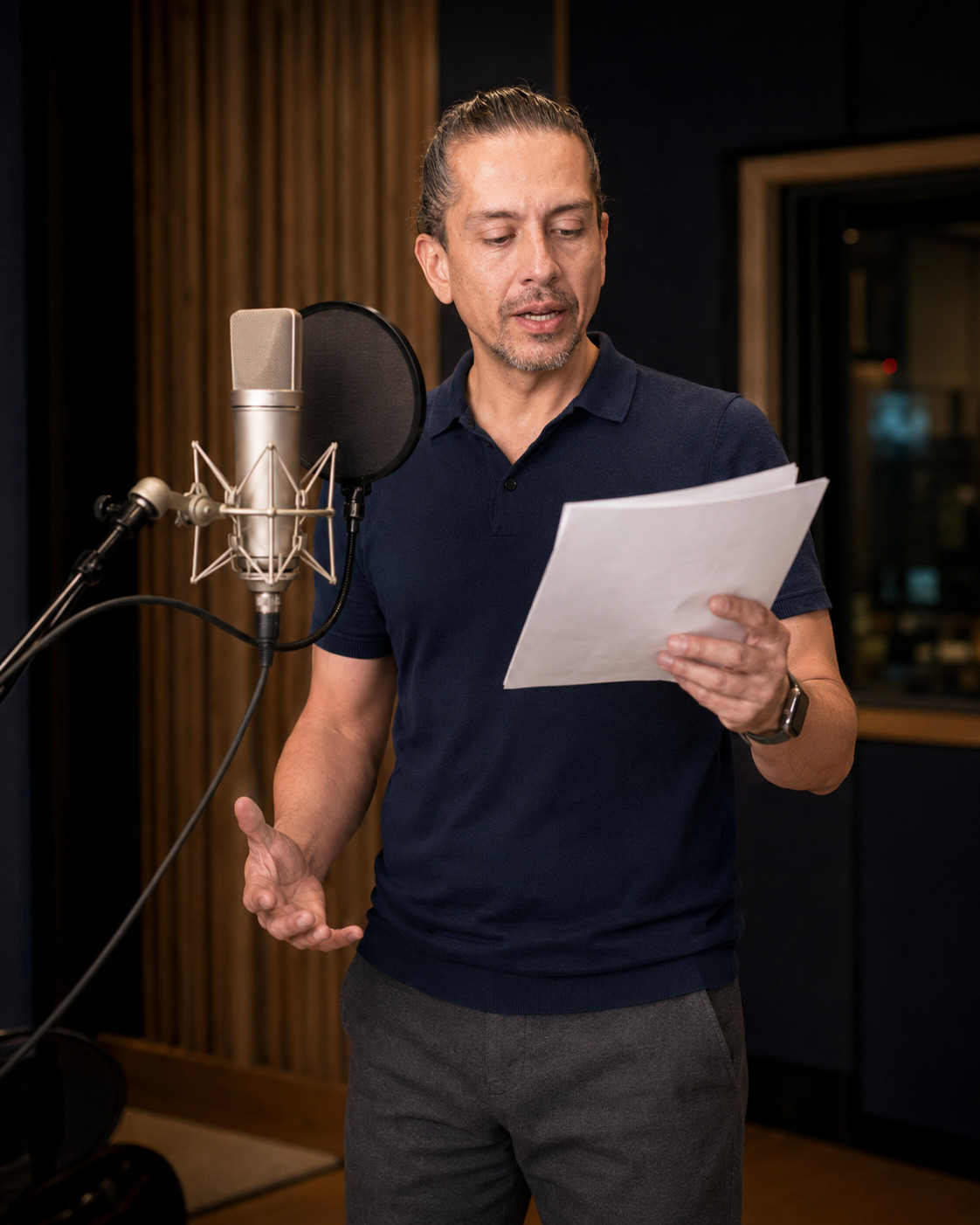 Galo Pérez interpretando un guion frente al micrófono en su estudio